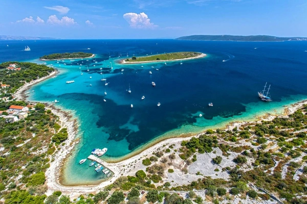 View of the turquoise-blue sea and the peaceful Blue Lagoon bay, surrounded by green islets and rocky shores under a clear sky